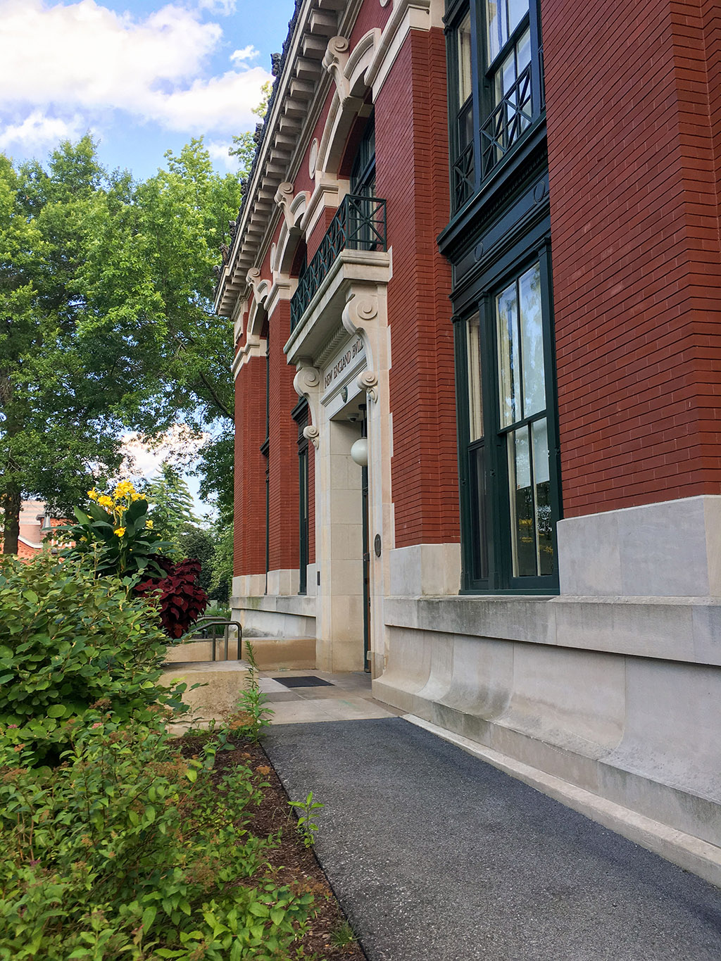 A brick building with a walkway and trees.