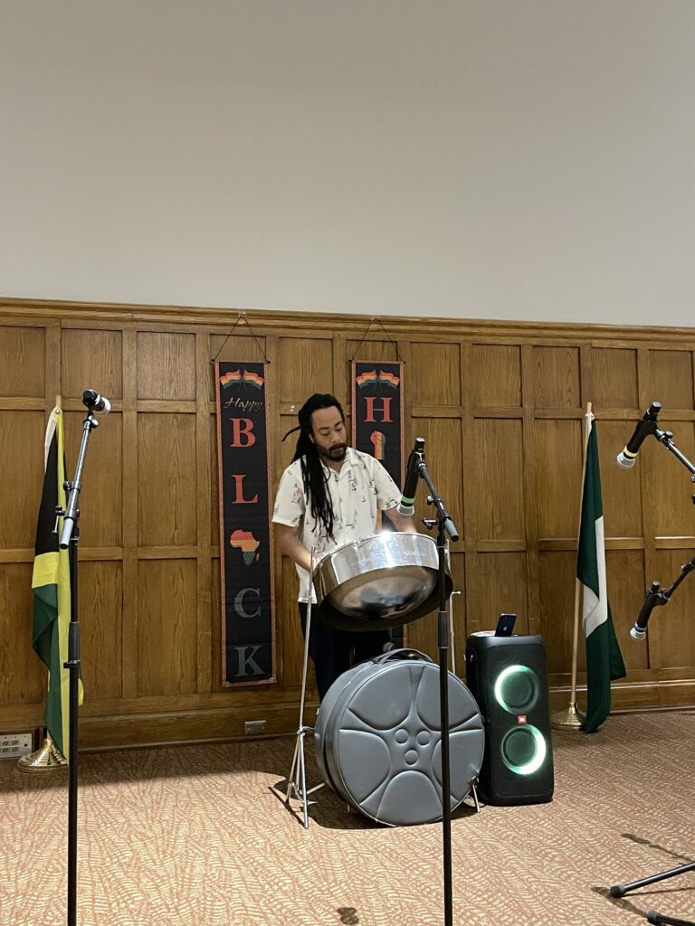 Mustafa Alexander using a steele drum in the front of the Villard Room during the Black History Month Kick off.