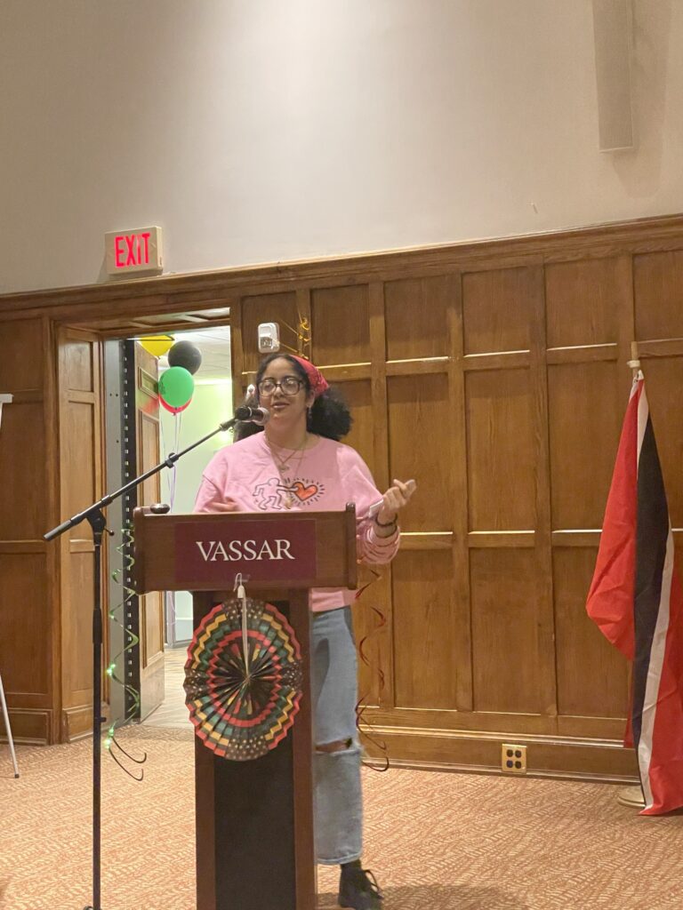 Student Moderator, Pierangelis Valerio standing at the podium introducing the next artist to the stage. 