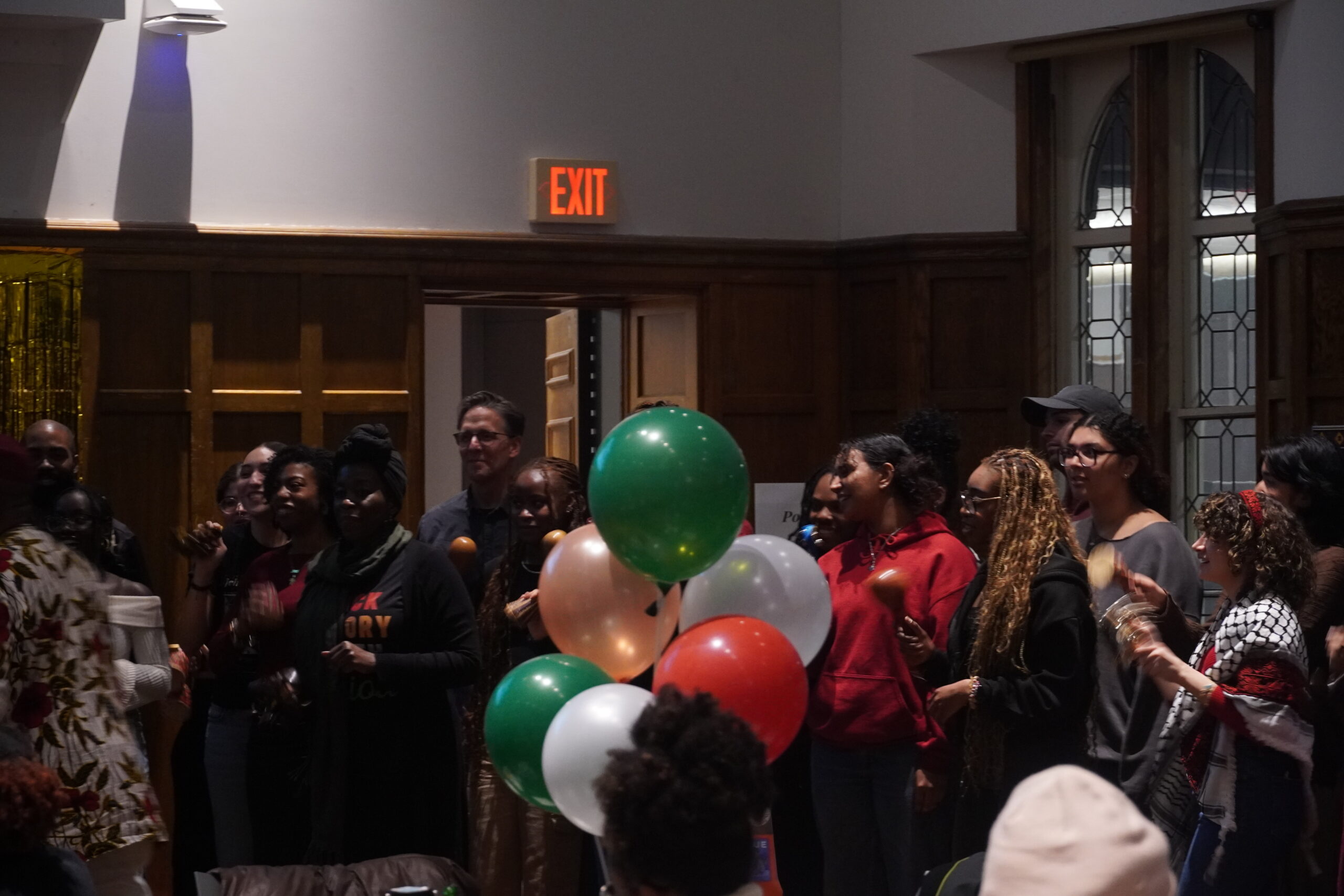Attendees standing in front of the Villard listening to Baba Kazi Oliver lead a drumming activity. 