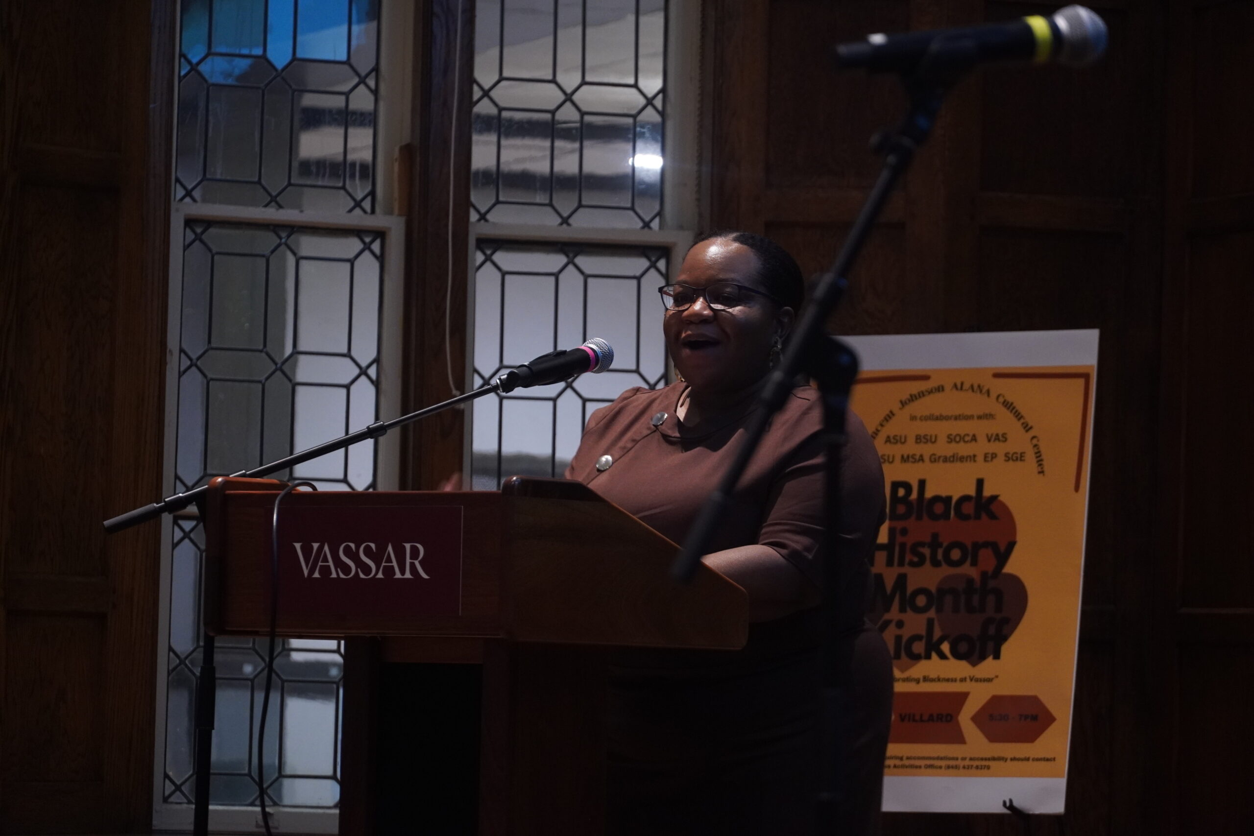Dr. Martin standing at the podium, talking into the mic, and facing the audience. 