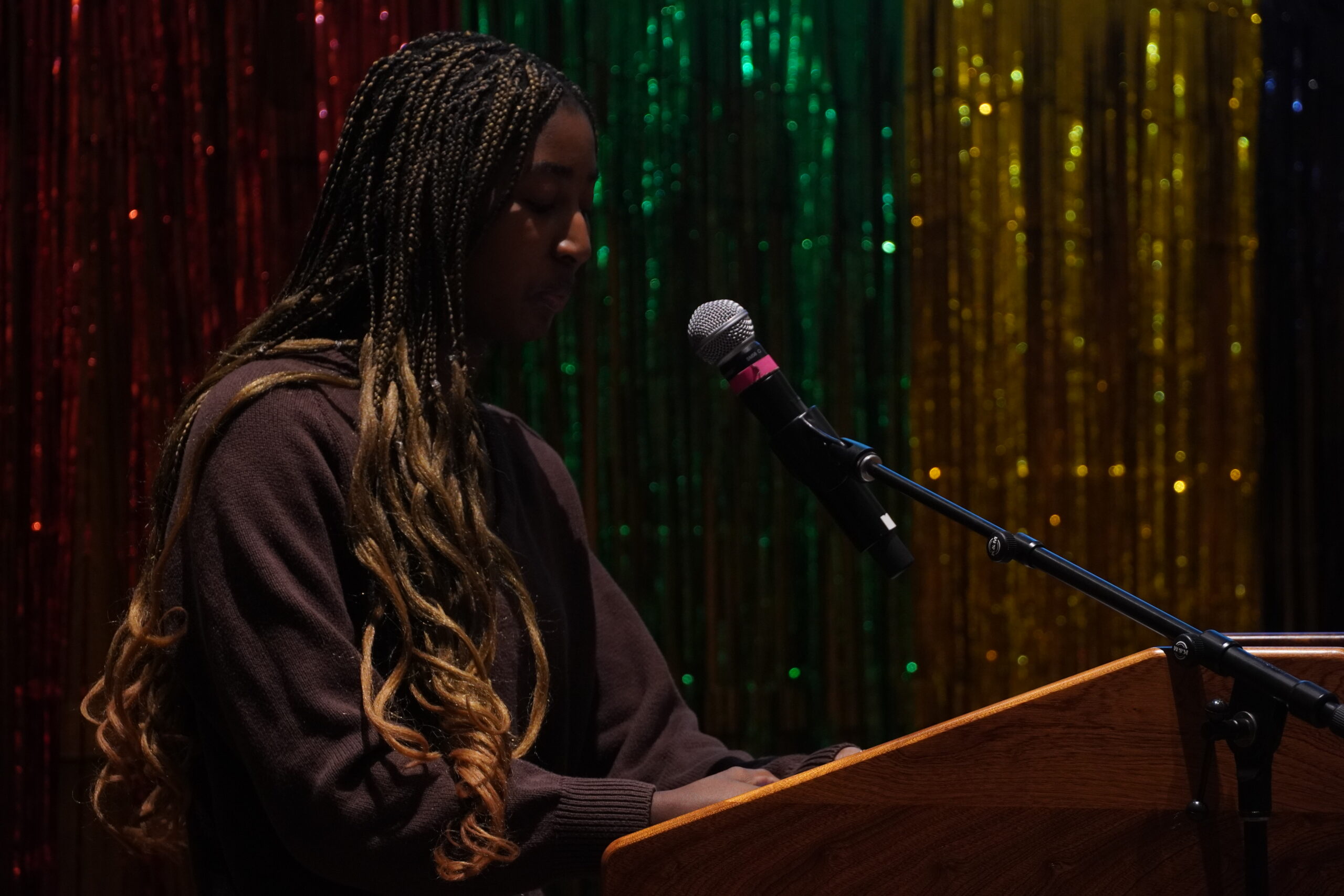 Olivia Sparks is standing at the podium and talking into the mic.  