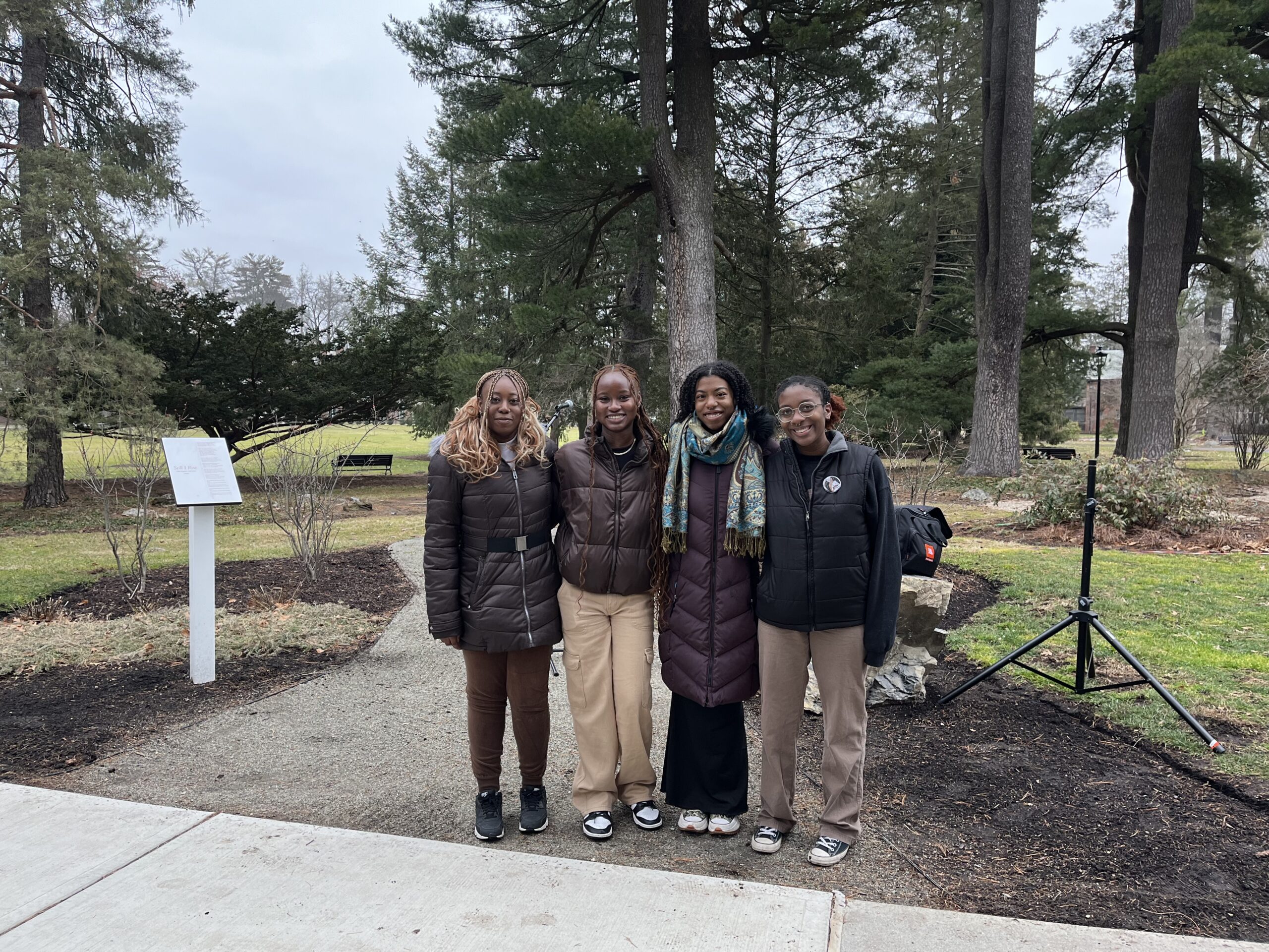 ALANA student leaders; Fanta Wague, Krystal Matthews, Marissa Desir and Mariah Jones (from left to right) standing side by side in front of the Garden to Celebrate Black Lives. 