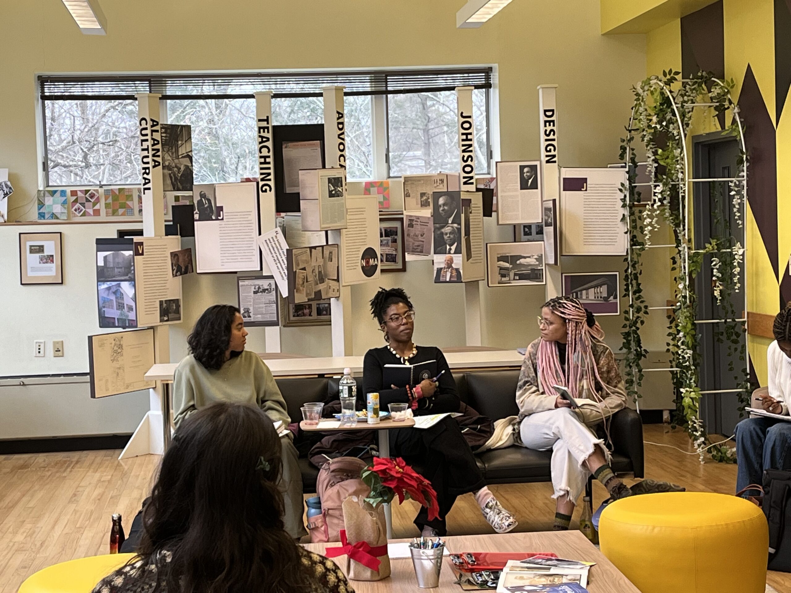 Three students seated side by side in the ALANA Community Room. 