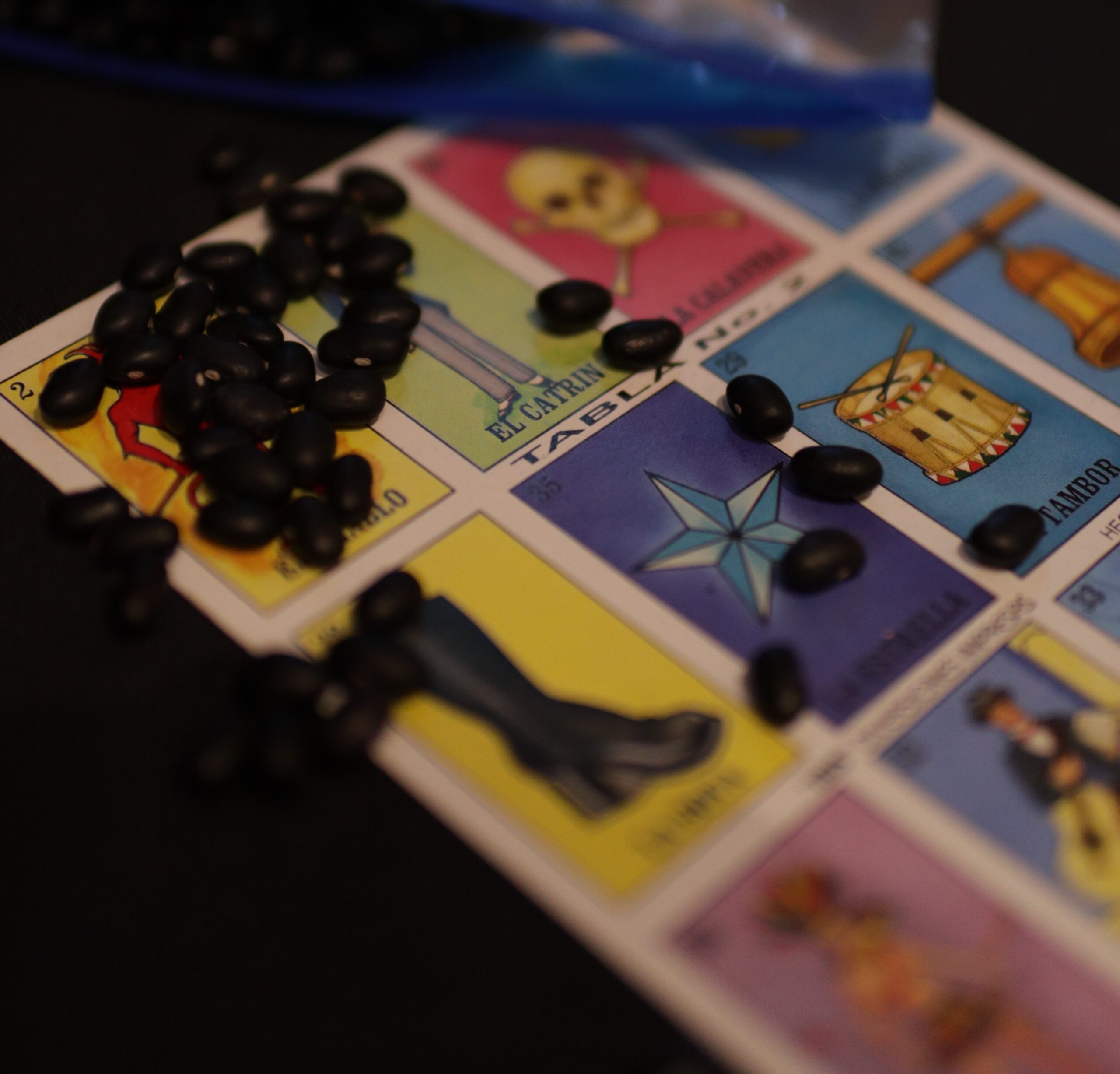 Loteria card with black beans on top of the card.
