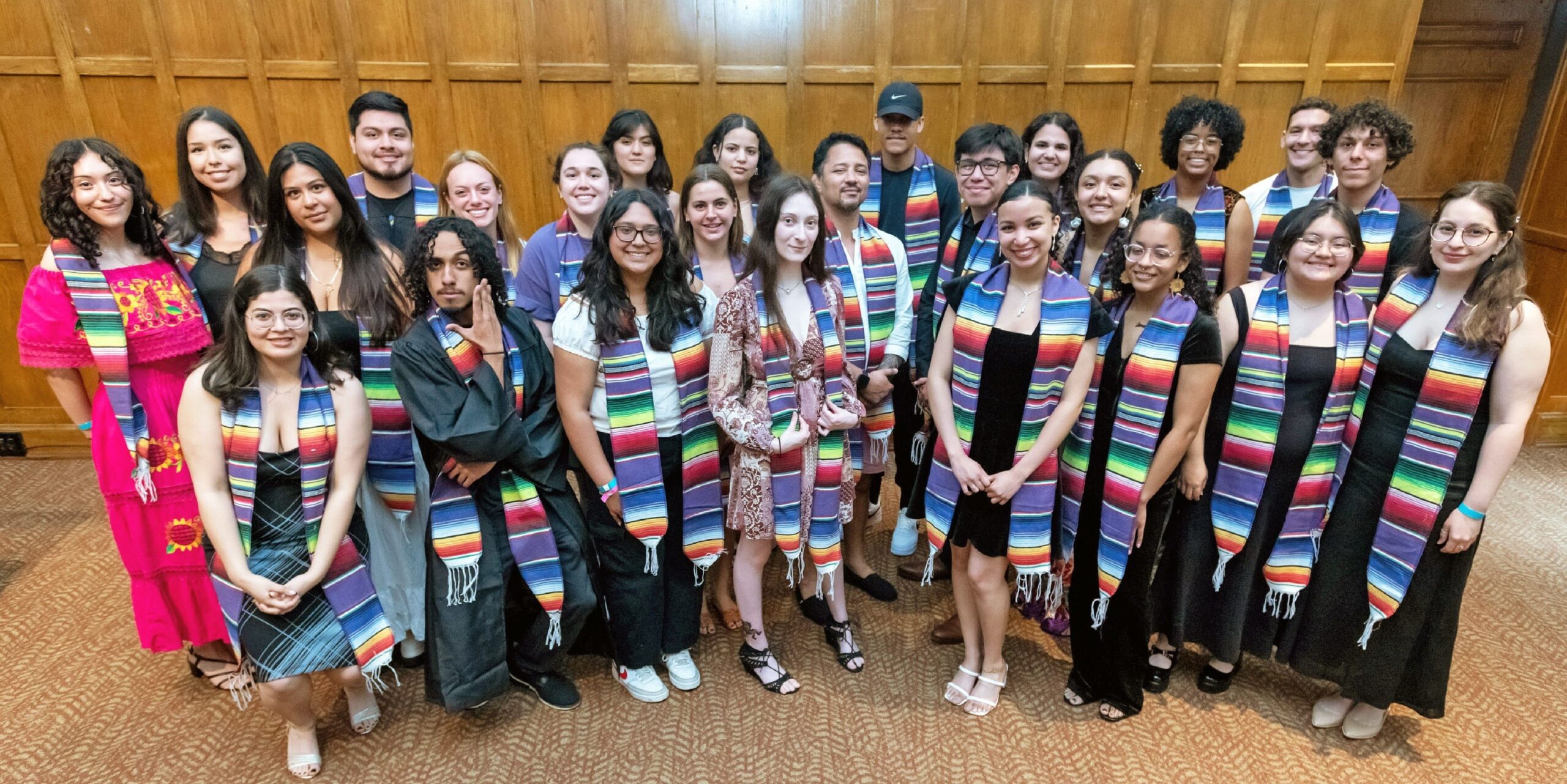 Group photo of twenty-five students after receiving their sarape stoles in the Villard room.