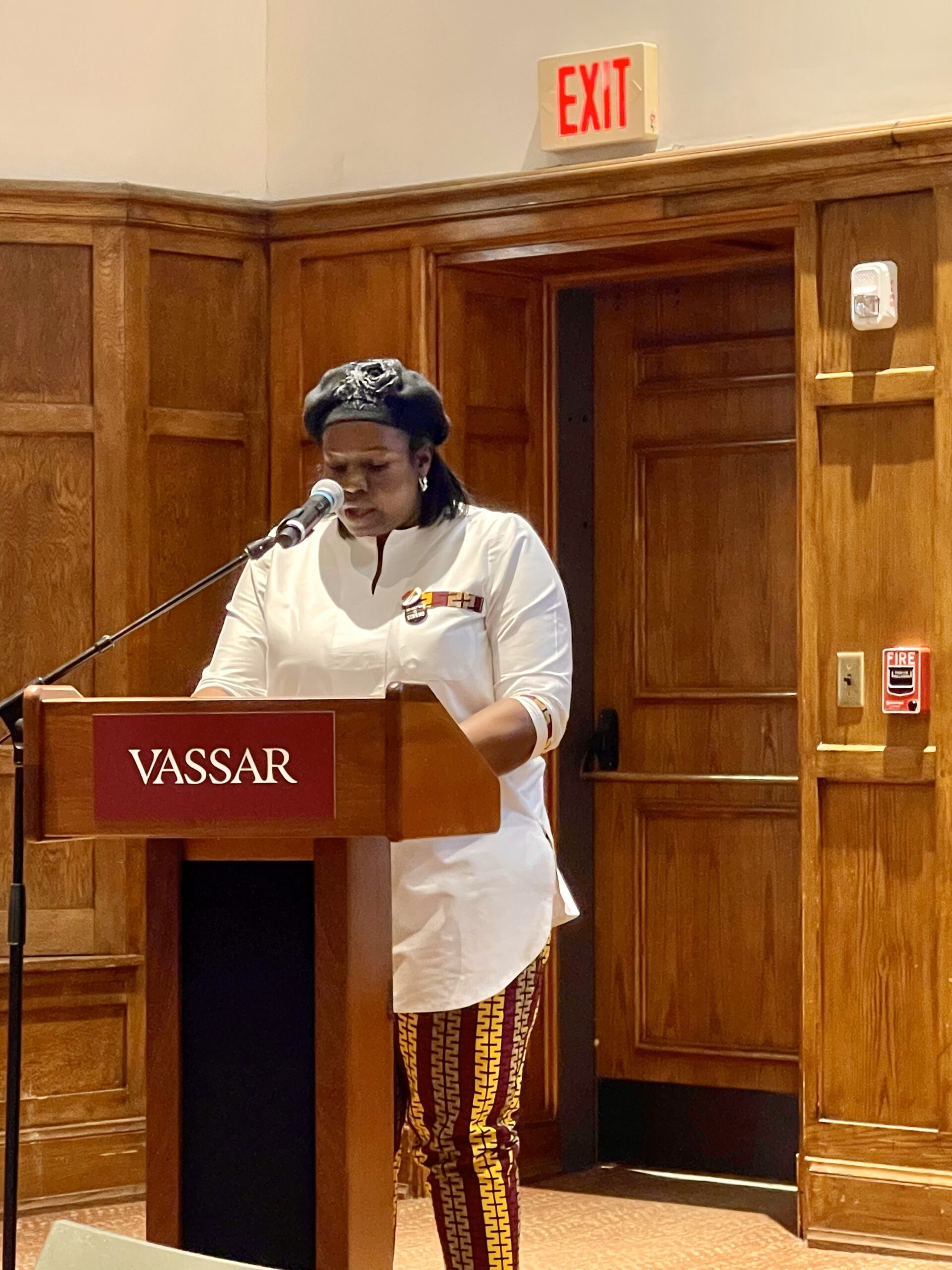 Dr. Nicole Beveridge standing at the podium looking down as she speaks into the mic.