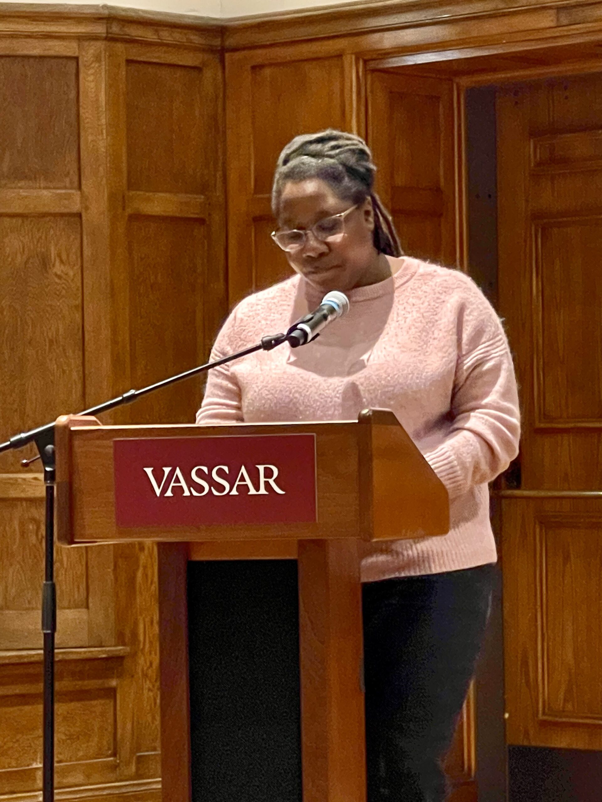 Dr. Tamyka Jordon-Conlin standing at the podium staring down as she speaks into the mic with her hands on the podium.