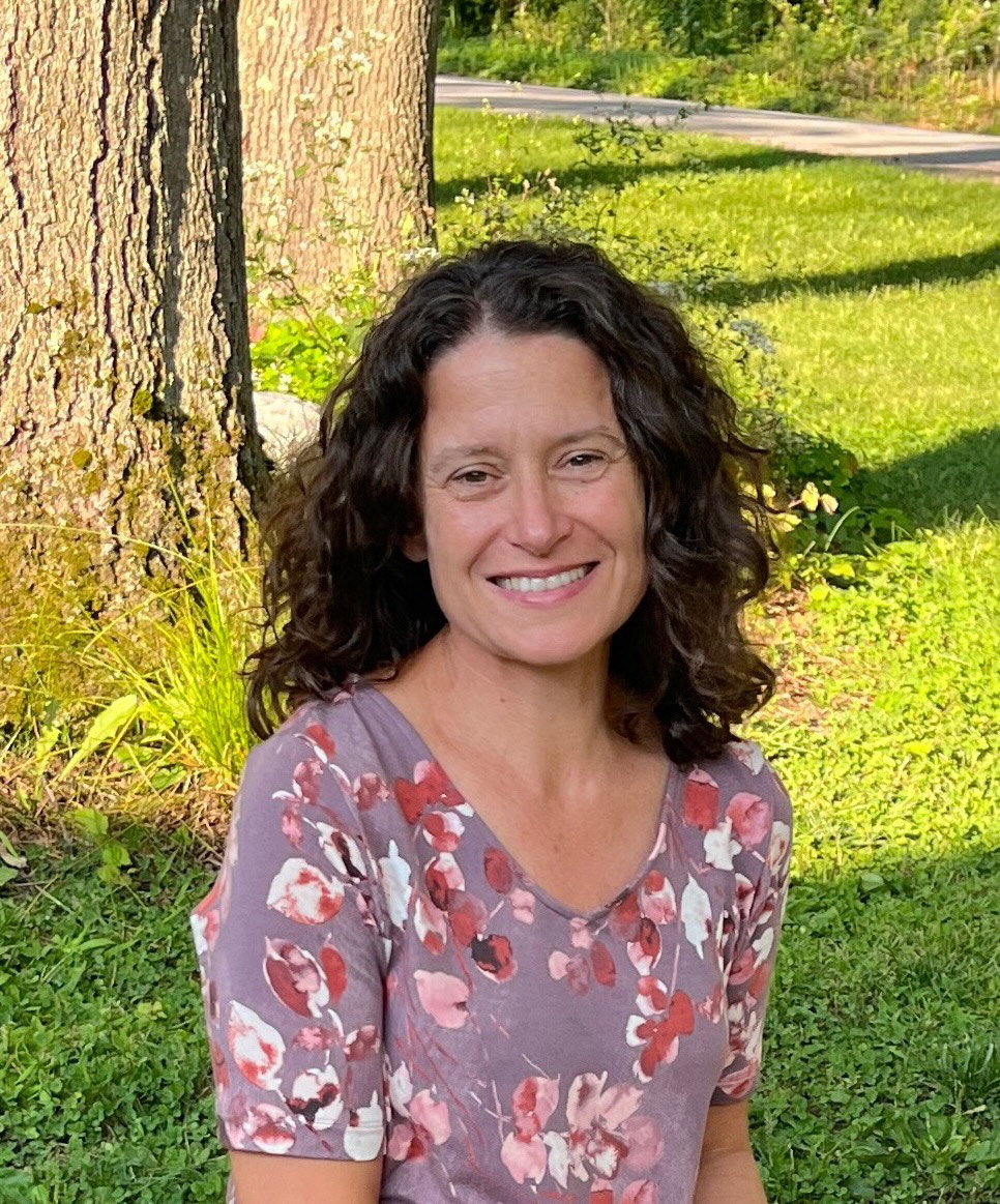 A portrait photo of a woman outside on a sunny day.
