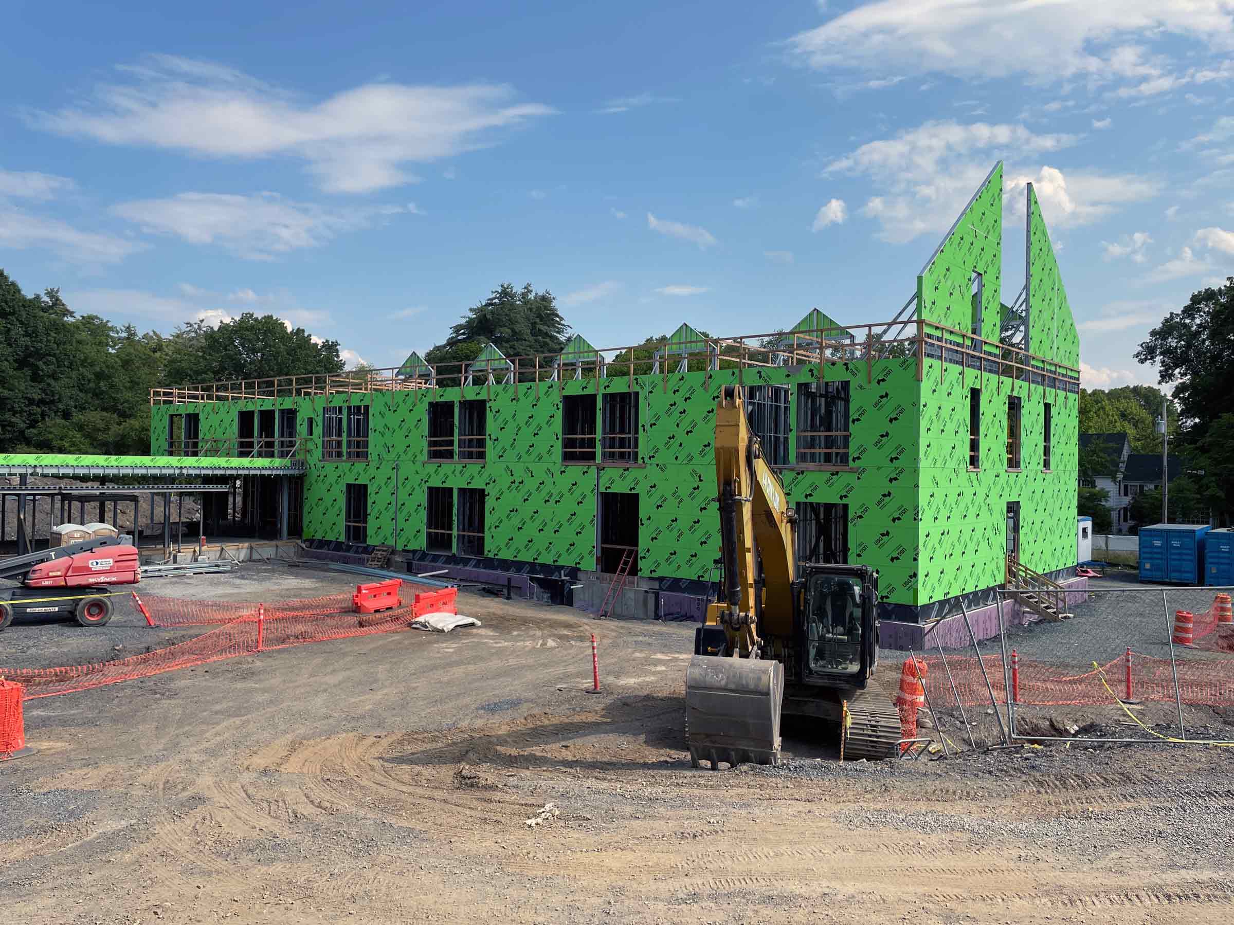 building in process of being constructed with green paneling