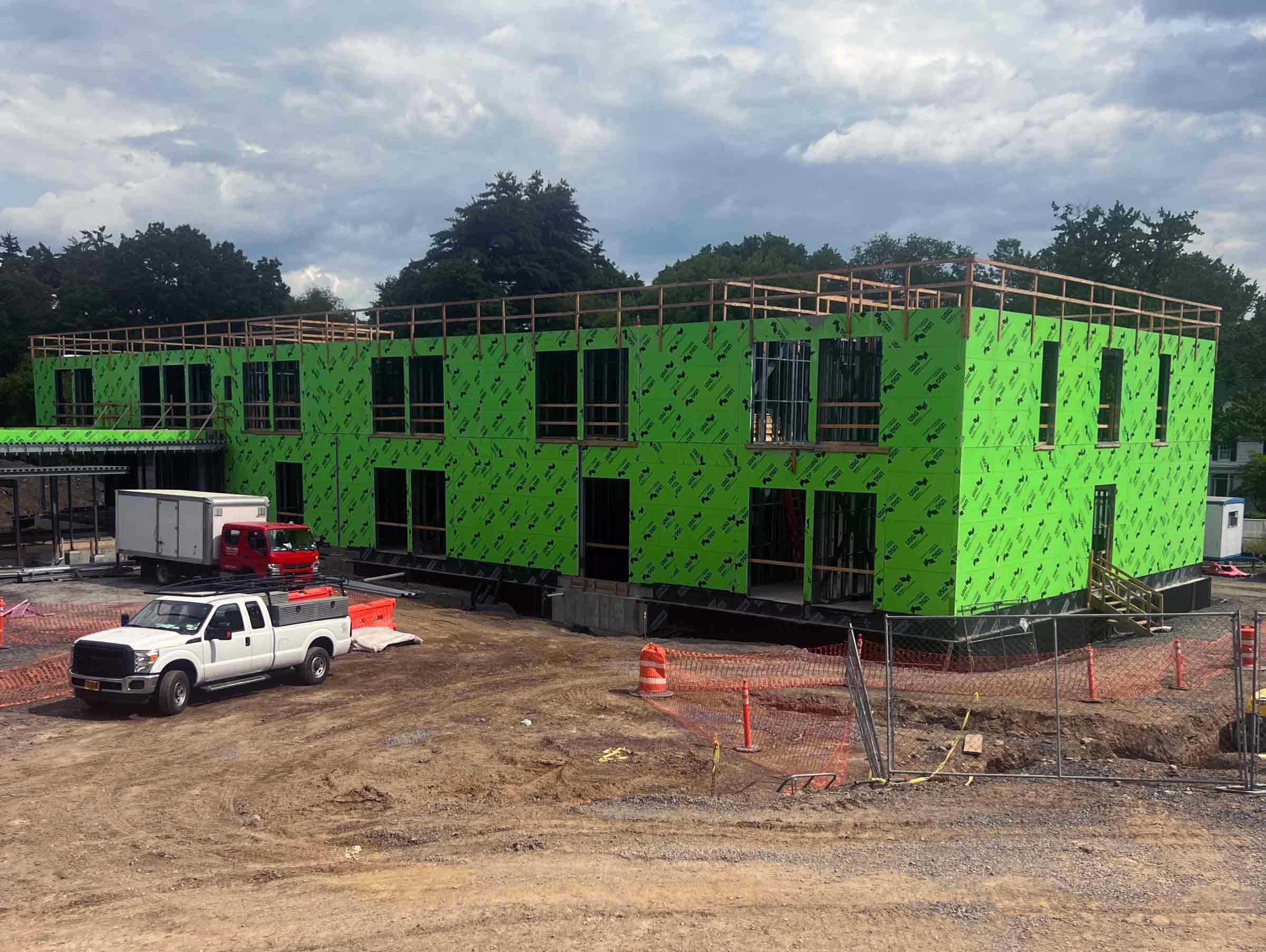building in process of being constructed with green paneling