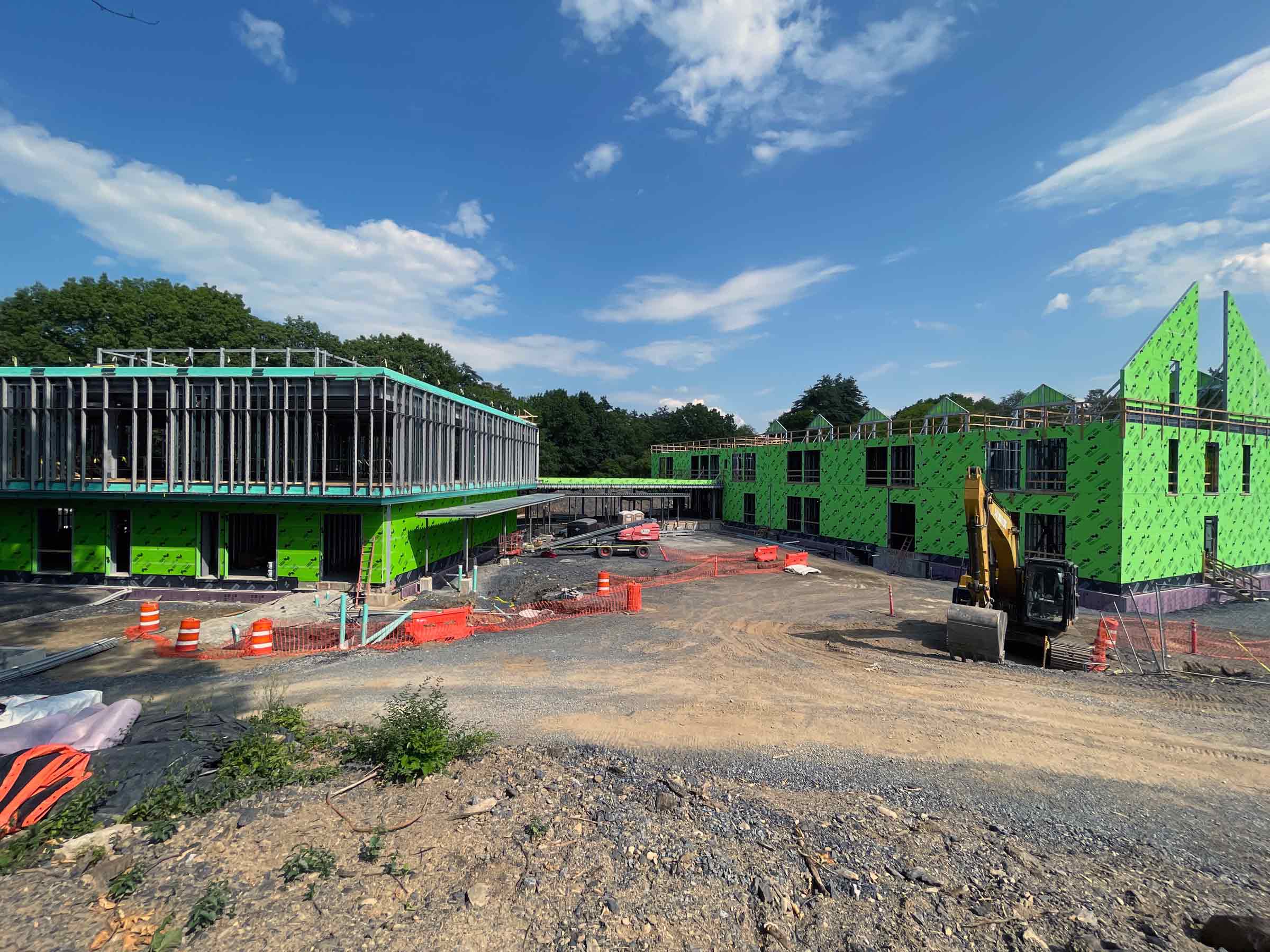 buildings in process of being constructed with green paneling and struts