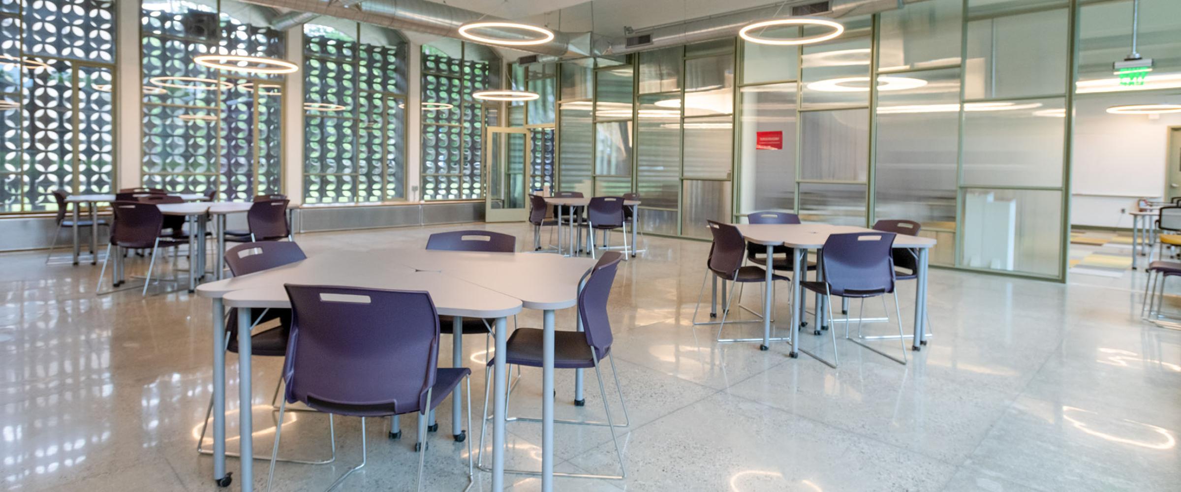 Photo of an interior space with tables with natural and artificial light.