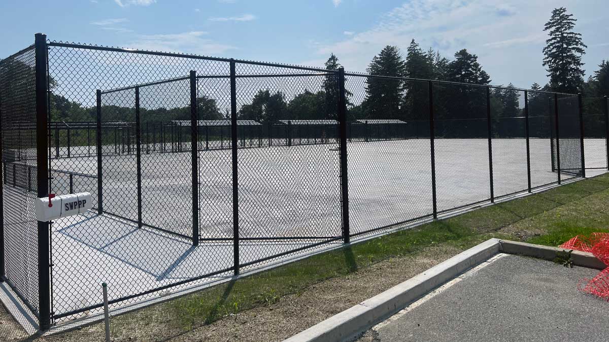 Empty tennis court with a black fence around it