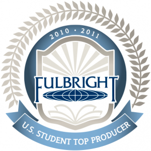 Official badge featuring the Fulbright Program logo inside a shield with rays of light and an open book, encircled by laurel leaves. The top reads '2010–2011' and a blue ribbon below states 'U.S. Student Top Producer'.