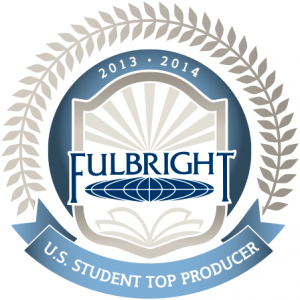 Official badge featuring the Fulbright Program logo inside a shield with rays of light and an open book, encircled by laurel leaves. The top reads '2013–2014' and a blue ribbon below states 'U.S. Student Top Producer'.