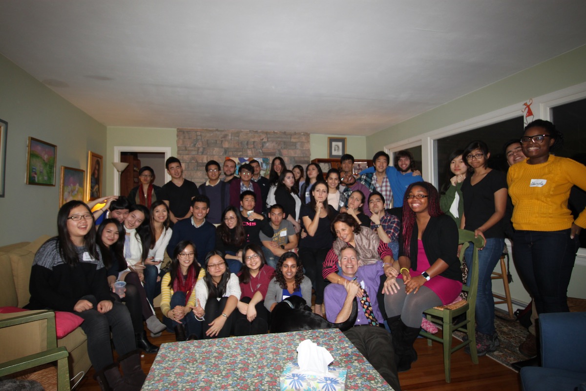 Large group of people posing in a small room with chairs and a couch.