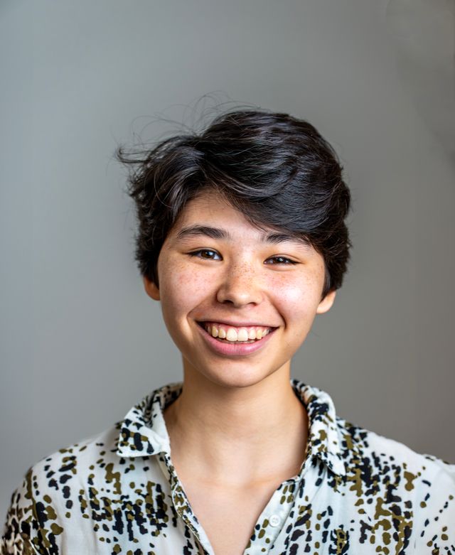 Dorien Laurens with short dark hair wearing a patterned shirt, smiling against a plain background.